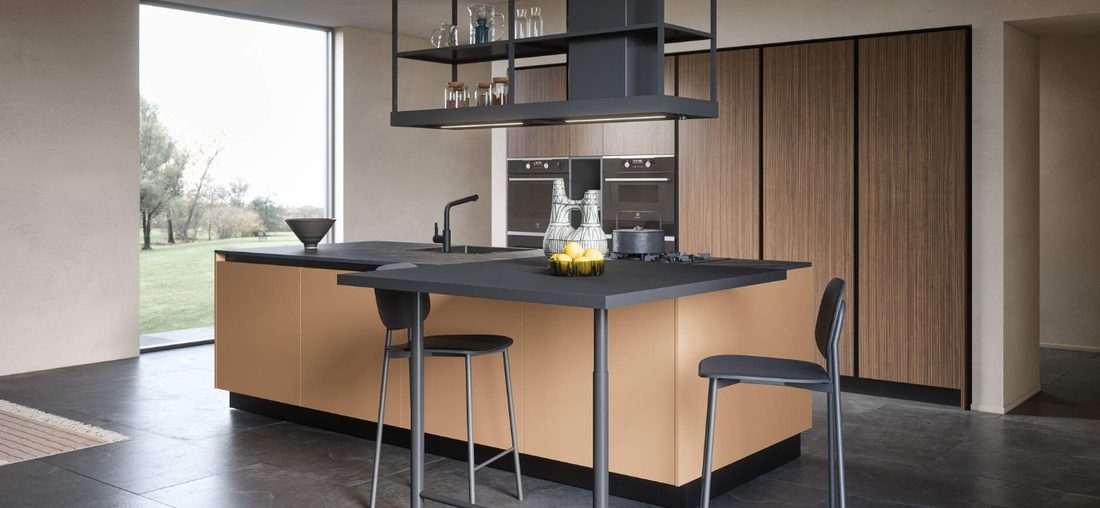Cucina con isola color rame e colonne in noce